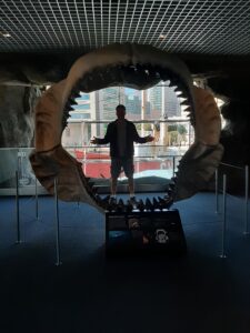 Justin standing in the megaladon jaws at baltimore aquarium